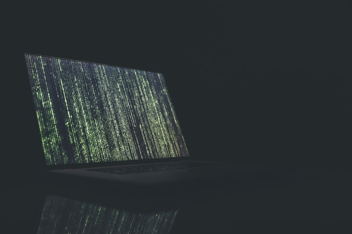A person working seriously at their laptop screen with cybersecurity lock indicators representing data privacy.